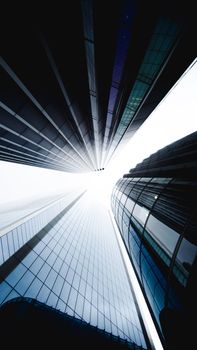 Low angle view of futuristic skyscrapers in London with glass facades reflecting light.