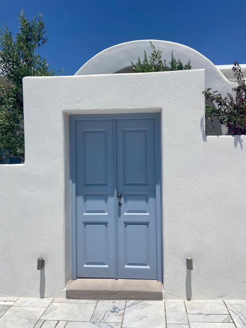 Free A classic blue door set in white architecture in sunlit Fira, Greece, showcasing Cycladic design. Stock Photo