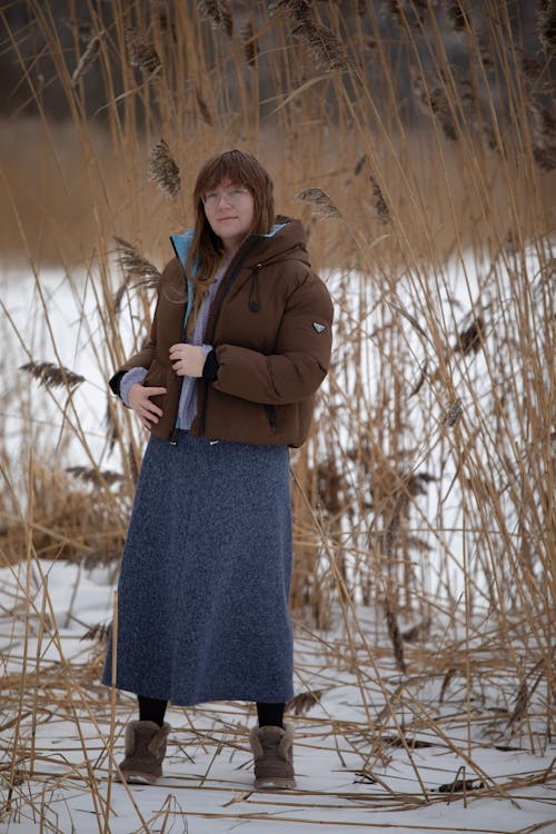 A woman standing in the snow wearing a coat