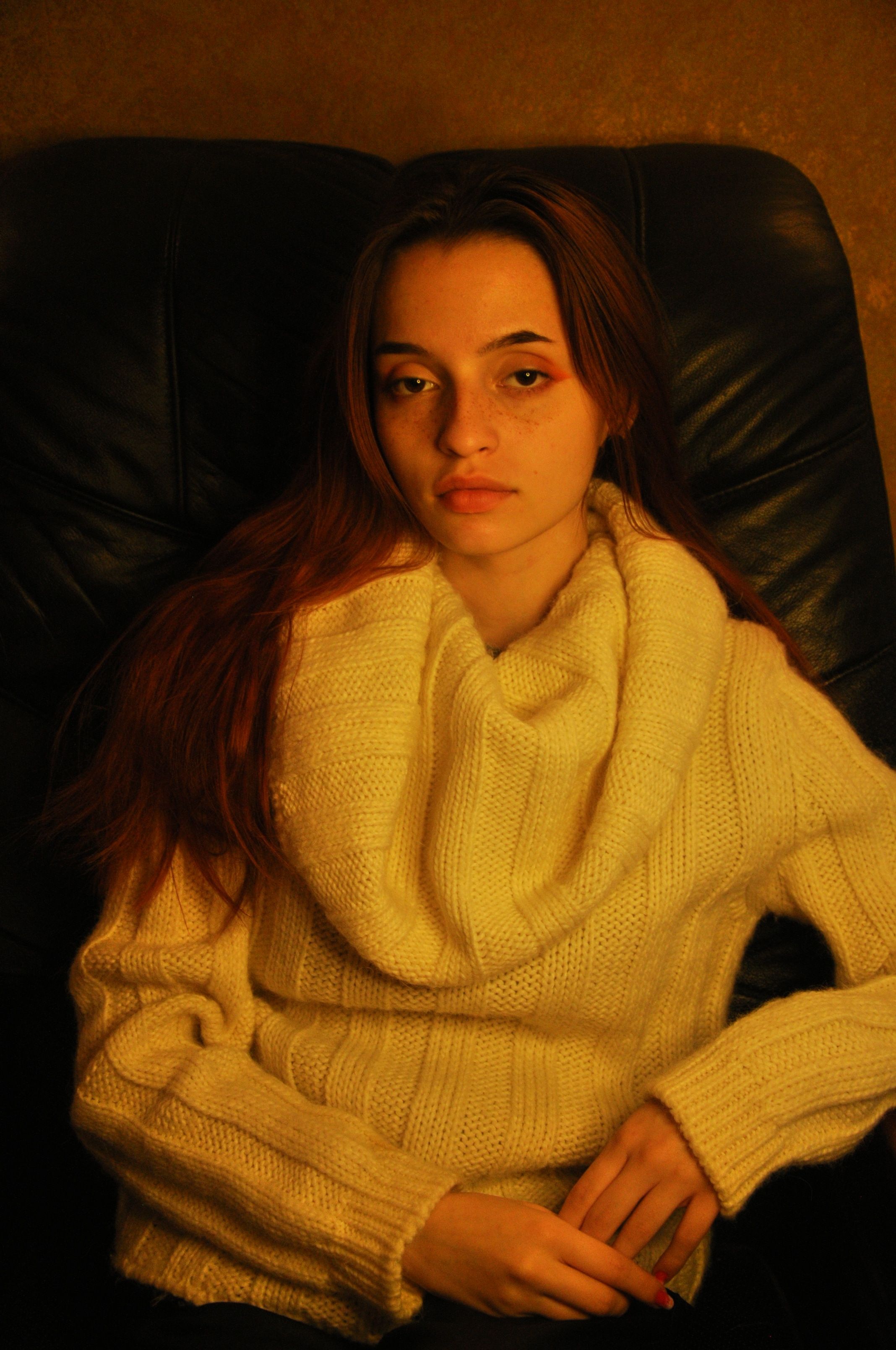 Warm portrait of a woman in a turtleneck sweater with vintage vibes indoors.