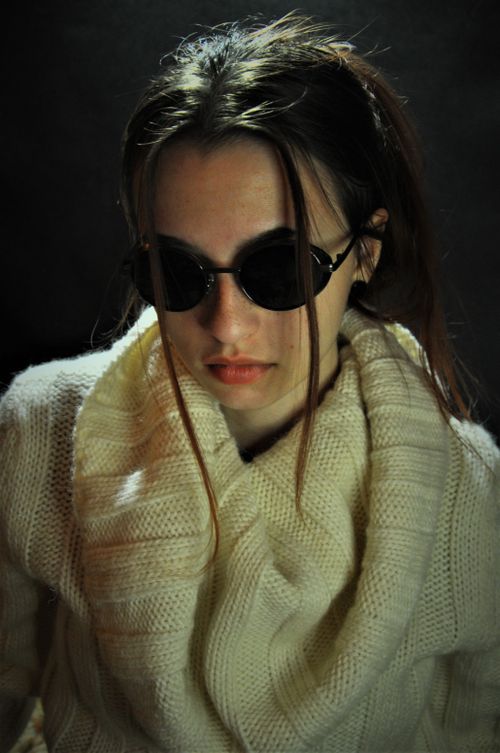 Free Portrait of a woman with sunglasses and a cozy white sweater, exuding modern fashion vibes. Stock Photo