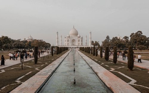 Free The Taj Mahal stands gloriously amidst lush gardens and a reflecting pool in Agra, India. Stock Photo