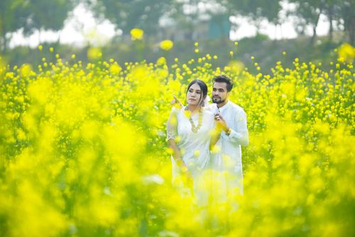 Free Young couple embracing in a vibrant yellow mustard field, exuding love and warmth. Stock Photo