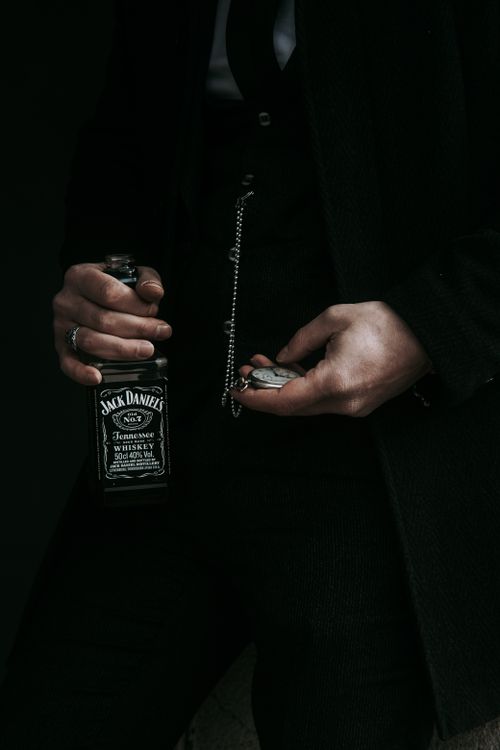 Free Retro style image of a man holding Jack Daniels whiskey and a pocket watch. Stock Photo