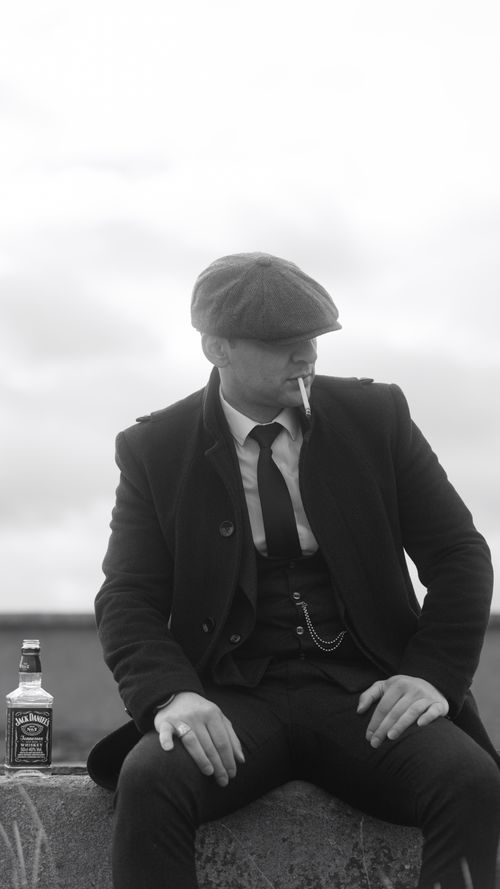 Free Black and white image of a man in 1920s attire with whiskey and cigarette. Stock Photo