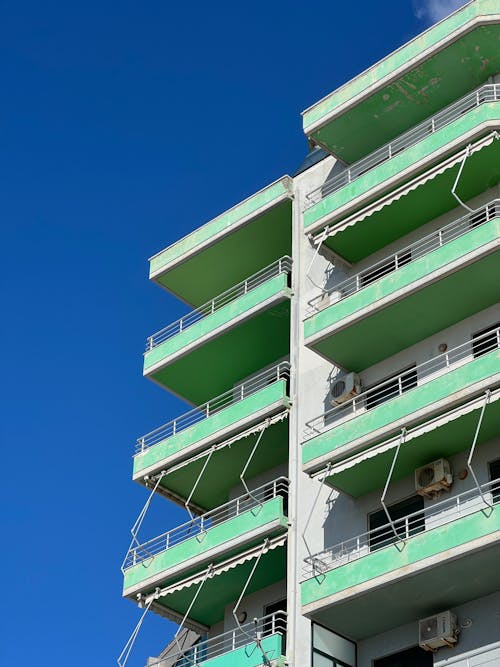 A tall building with green balconies and balconies