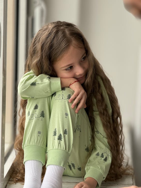 Portrait of a Long-Haired Girl Wearing Green Pajamas