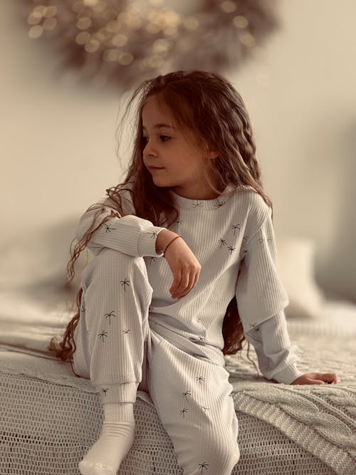 Free Girl in Pyjama Sitting on Bed Stock Photo