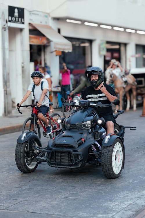 Men Riding Bike and Three-wheeler