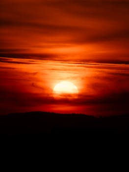 Vibrant red sunset with dramatic clouds over the German landscape, capturing a serene evening.