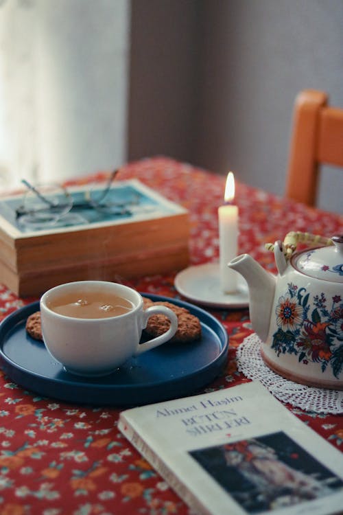 Wax Candle, Tea and Book on Table