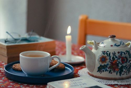 Free Warm and inviting tea setup with cookies and candle, perfect for relaxation and comfort. Stock Photo