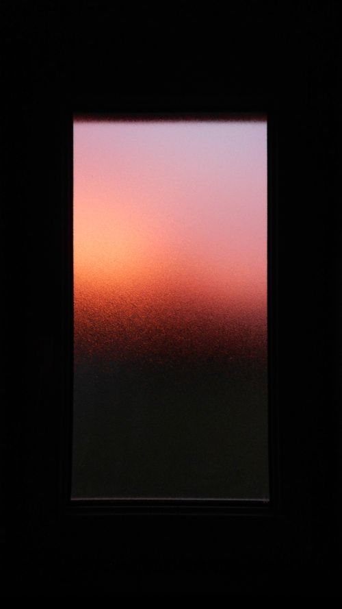 Free Captivating view of a sunrise with warm hues seen through textured glass window, creating a serene ambiance. Stock Photo
