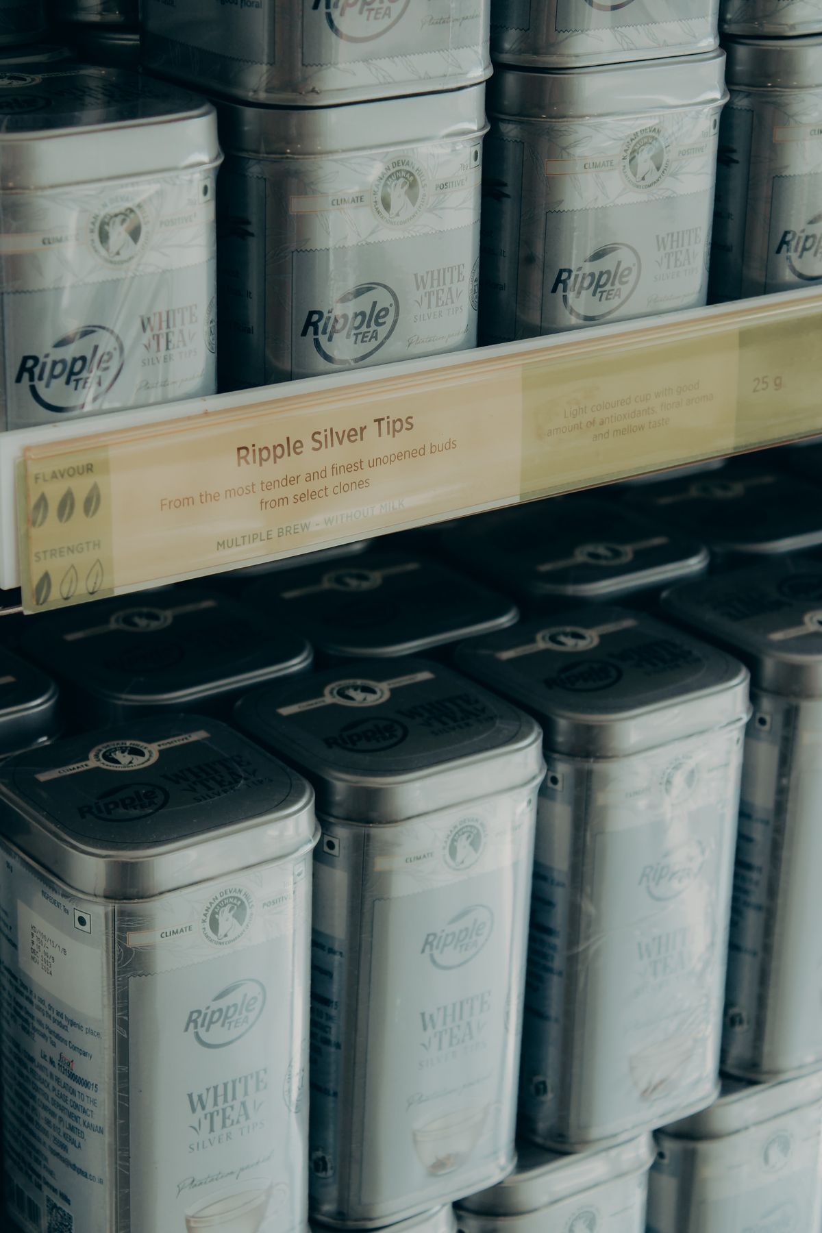 Tins of an estate's own white tea stacked on the shelves of a tea garden shop in Munnar, India