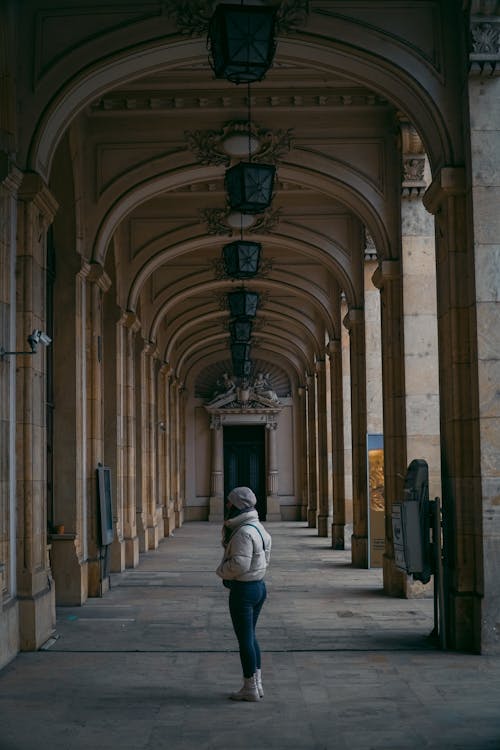A woman walking down an empty hallway