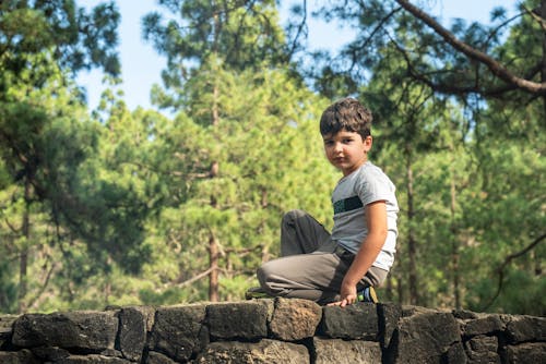 Boy Sitting on a Stone Wall