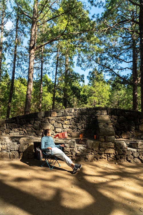 Tourist Sitting at a Stone Barbecue in the Forest