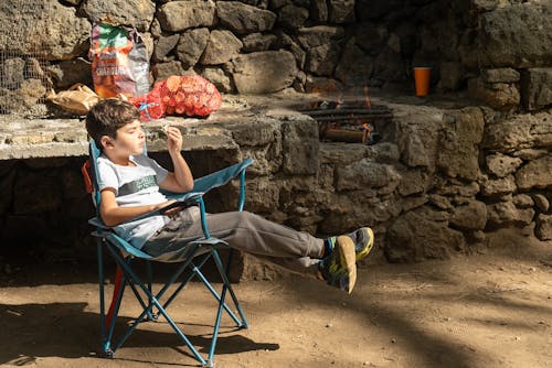 Boy Sits in Camping Chair