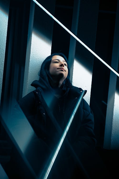 Woman in Black Jacket Standing by Wall