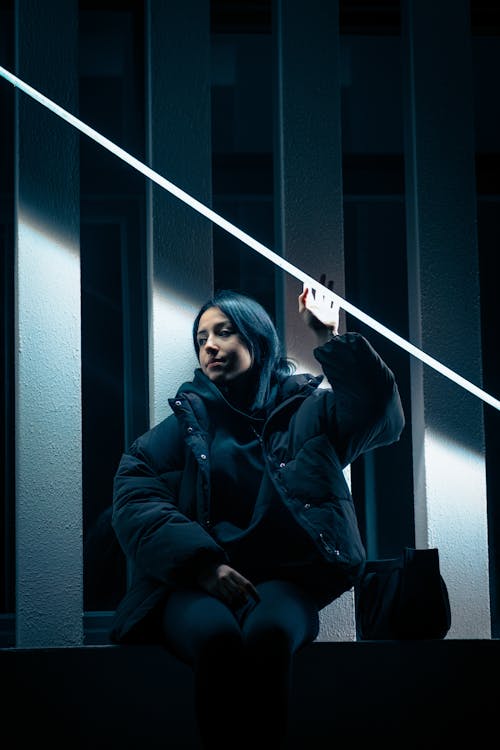 Free Young Woman Wearing a Black Jacket Sitting on a Bench Stock Photo