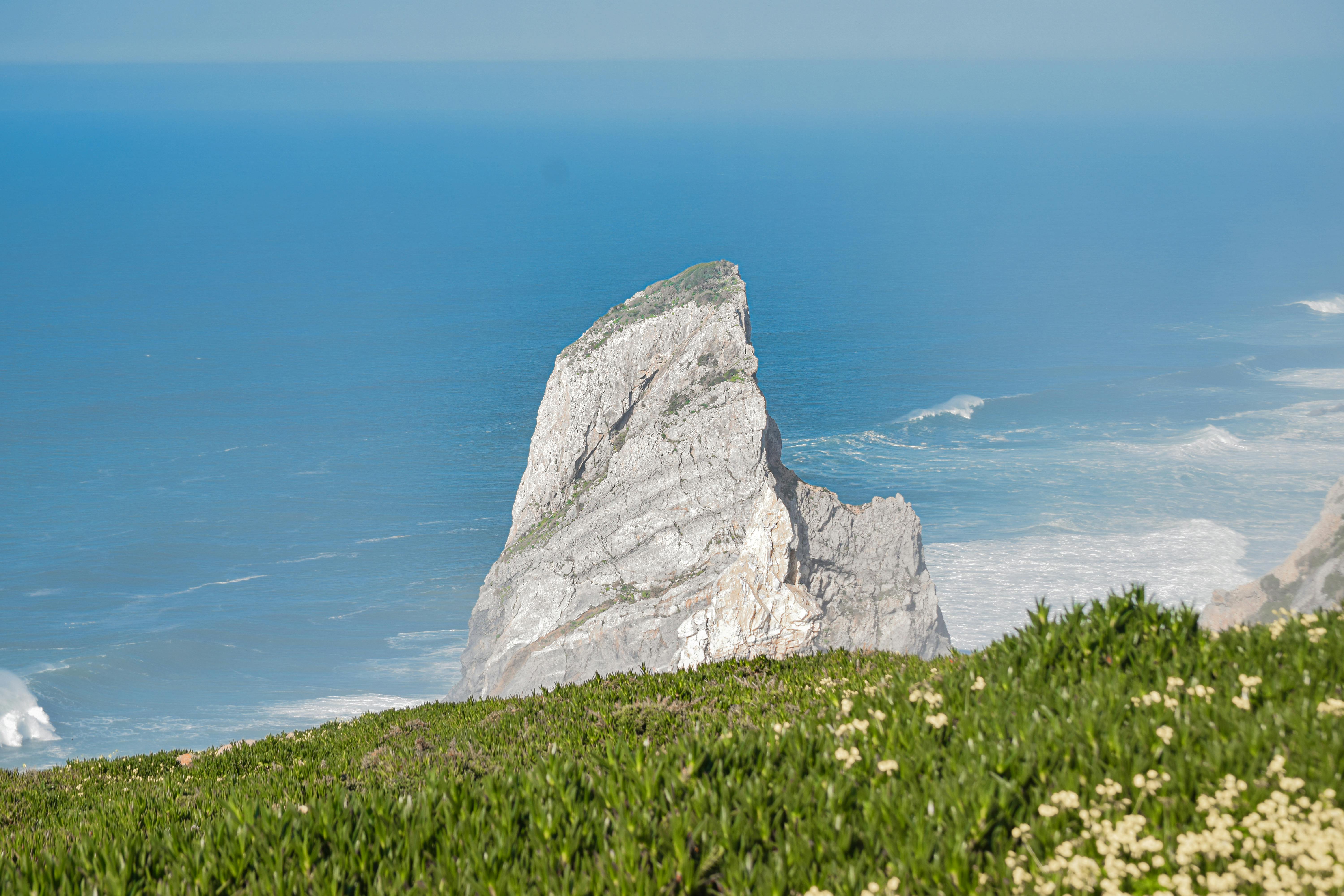 A stunning view of Cabo da Roca's iconic cliff rock with the Atlantic Ocean backdrop in Portugal.