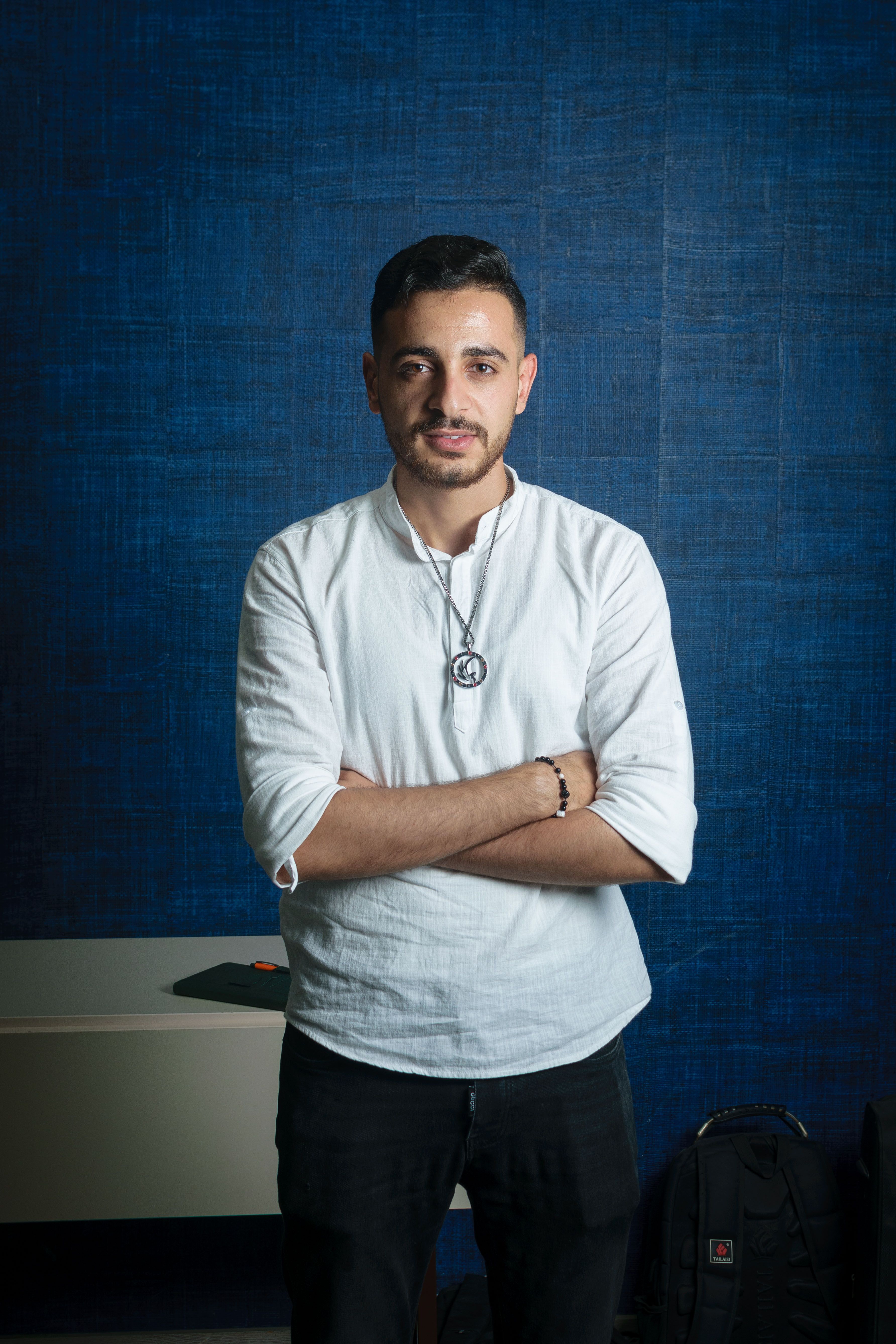 Fashion portrait of a man in white shirt with blue background. Casual elegance meets contemporary style.