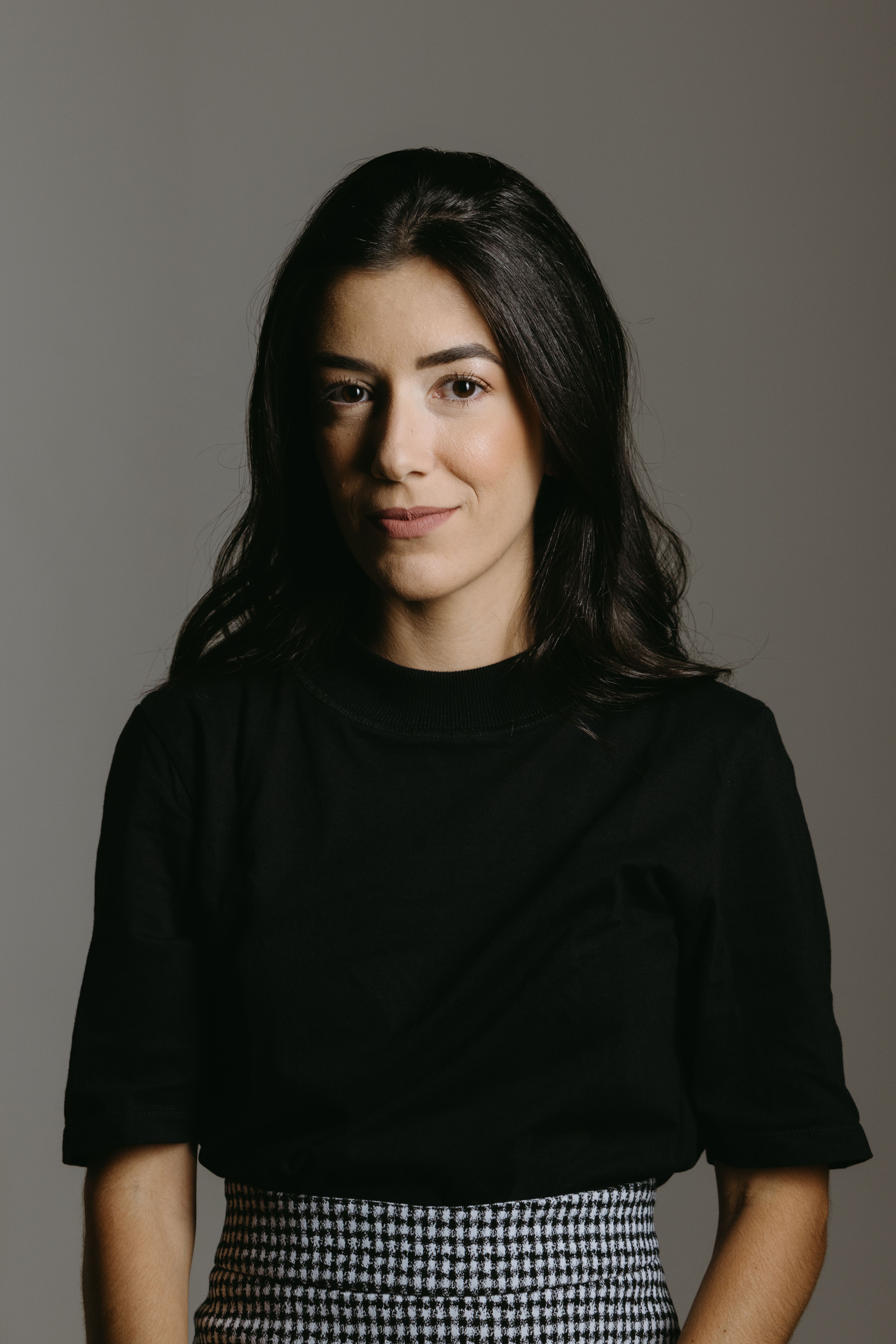 Stunning studio portrait of a young woman in elegant black blouse. Perfect for fashion and lifestyle imagery.