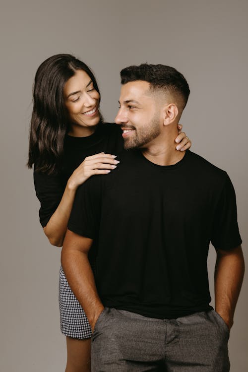 Studio Shot of a Couple in Fashionable Outfits Posing and Smiling 