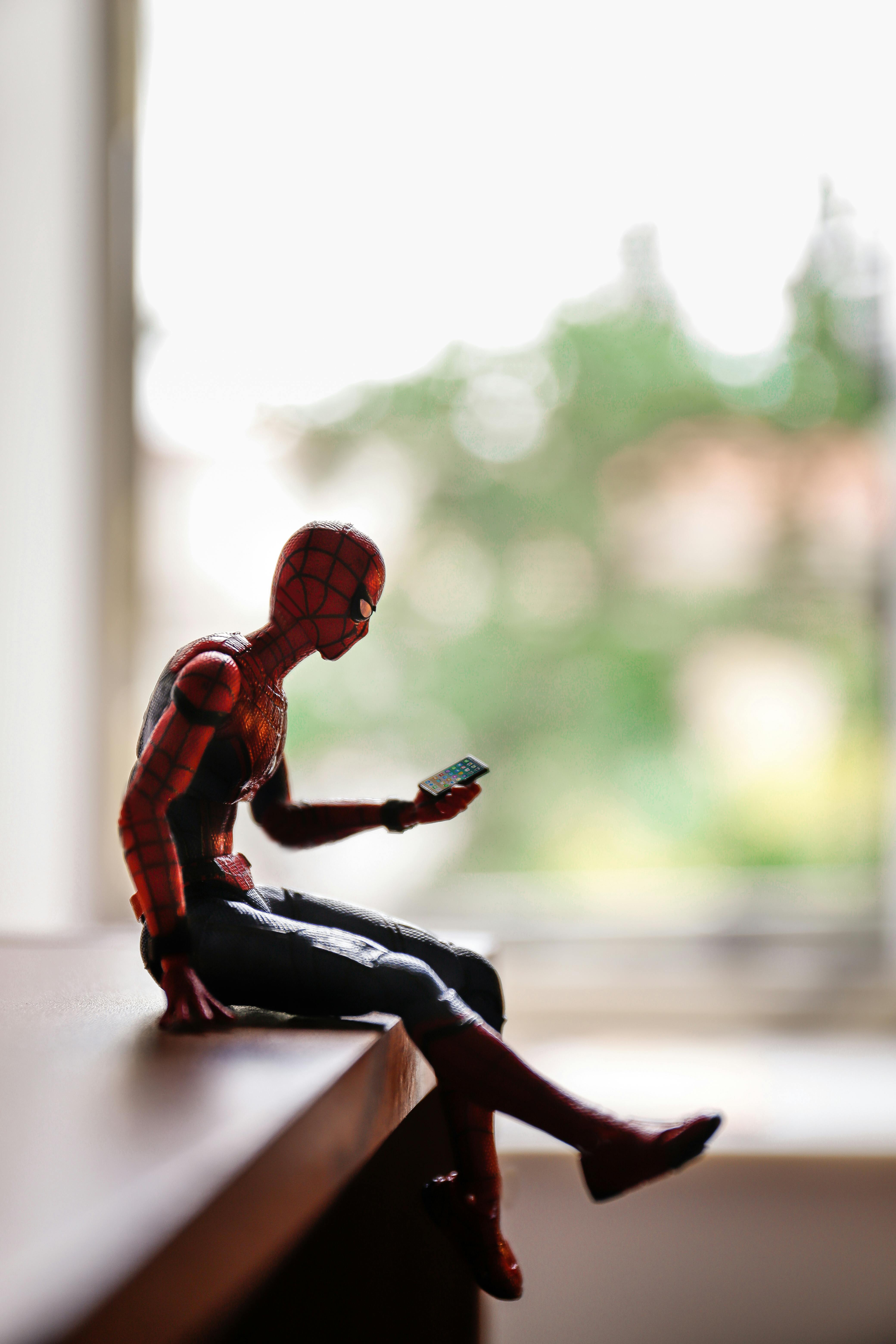 close up of a spiderman figurine sitting on a piece of furniture