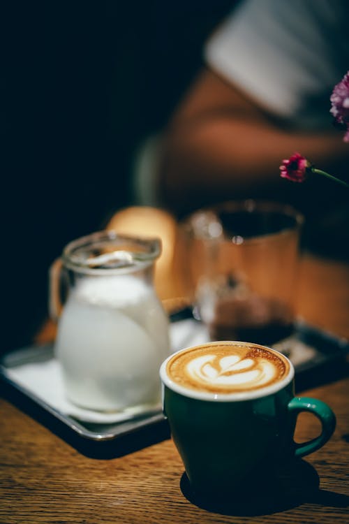 Free Cup of Coffee Latte Near Cream Pitcher Stock Photo