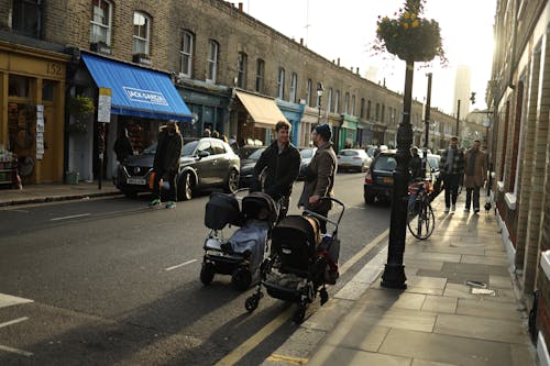 Fathers Standing with Strollers and Talking on Street