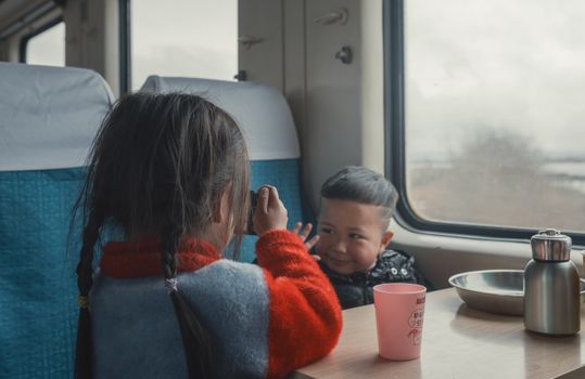 Two children playing inside a train cabin, capturing moments and enjoying the ride.