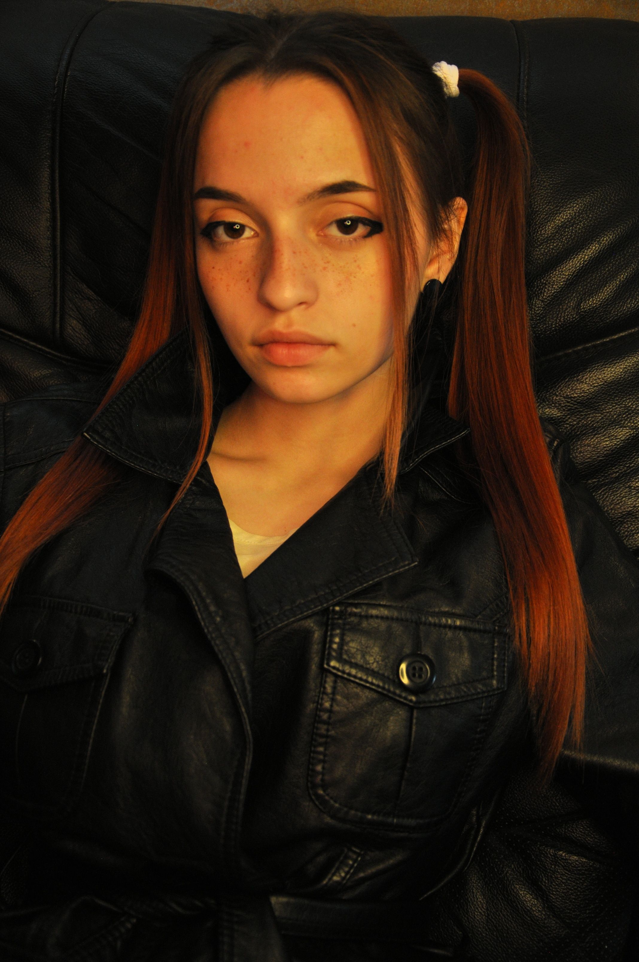 Captivating portrait of a woman with ponytails wearing a leather jacket, exuding a modern style.