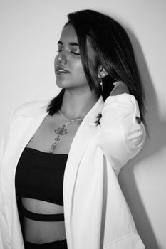 Stylish black and white portrait of a woman in a white jacket and black top