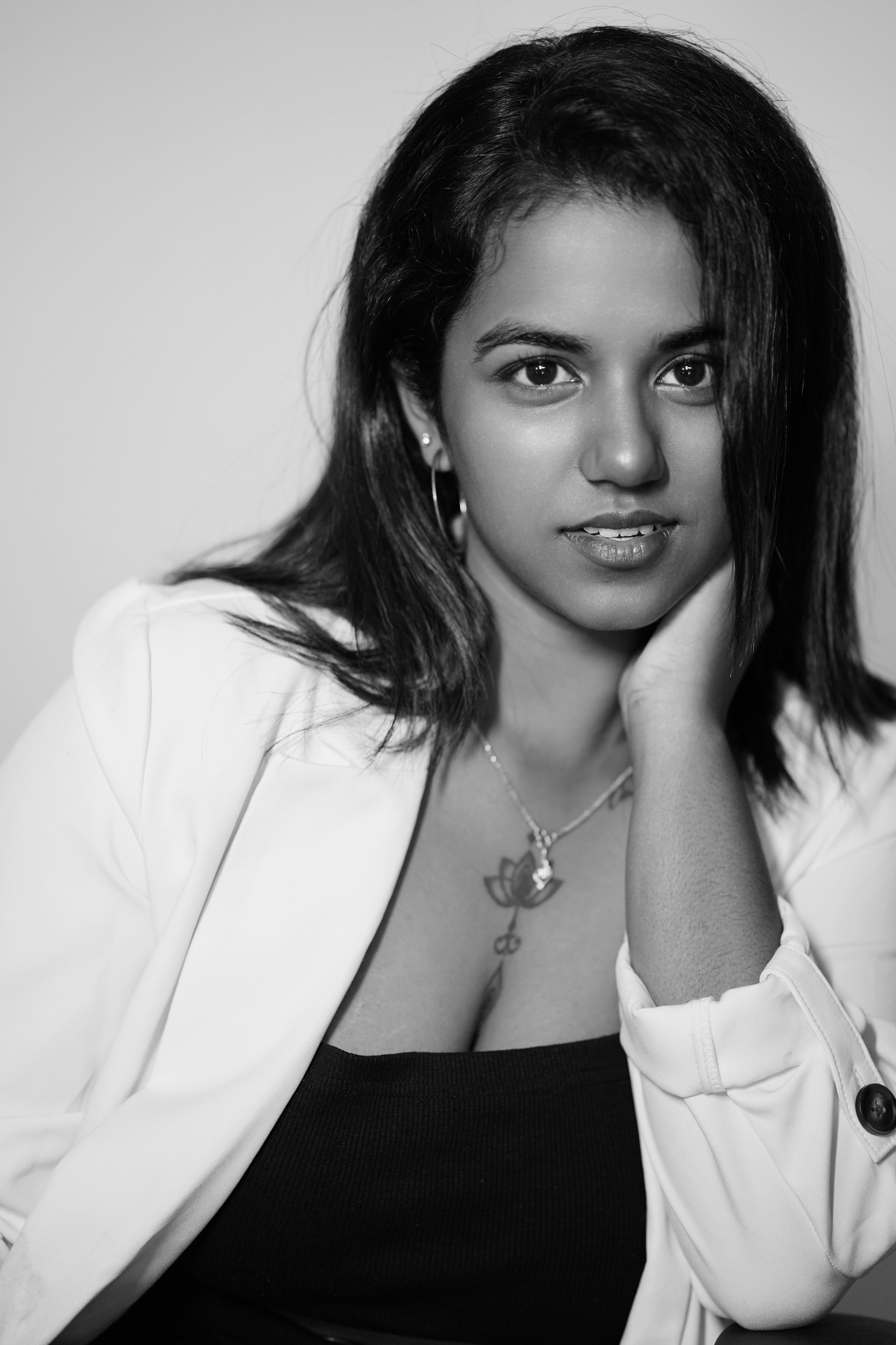 Stunning black and white portrait of a woman in a white jacket, exuding elegance and style.