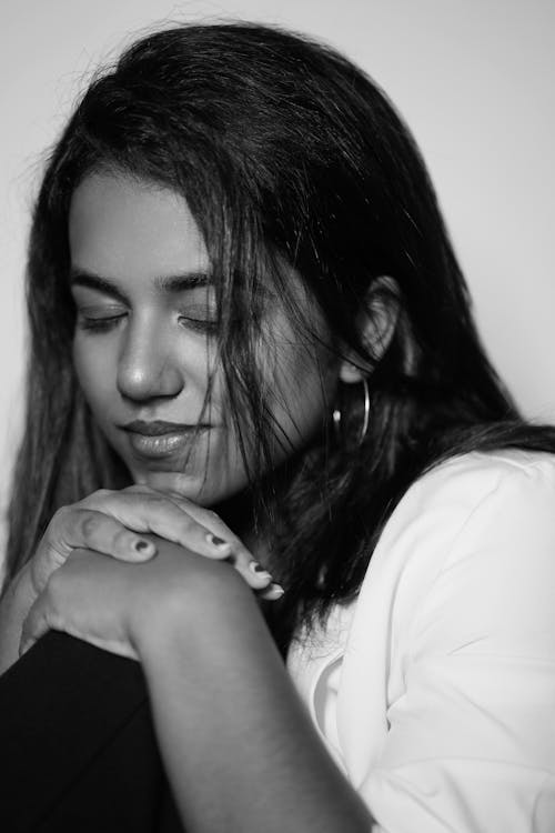 Black and White Photo of a Young Woman Sitting with Eyes Closed 