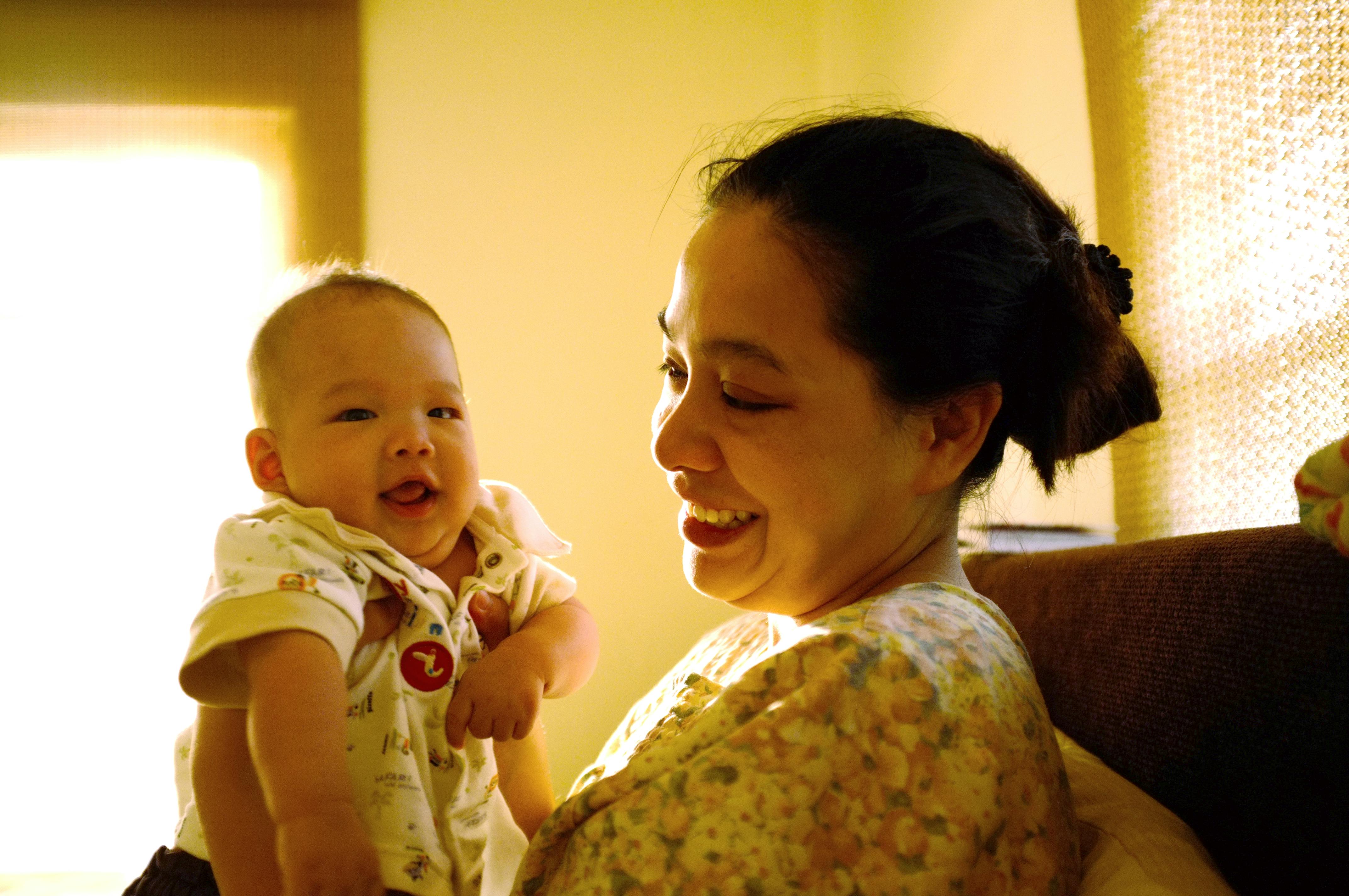 woman holding her baby in a yellow interior