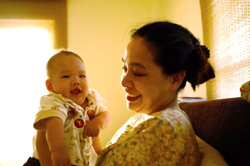 Woman Holding Her Baby in a Yellow Interior