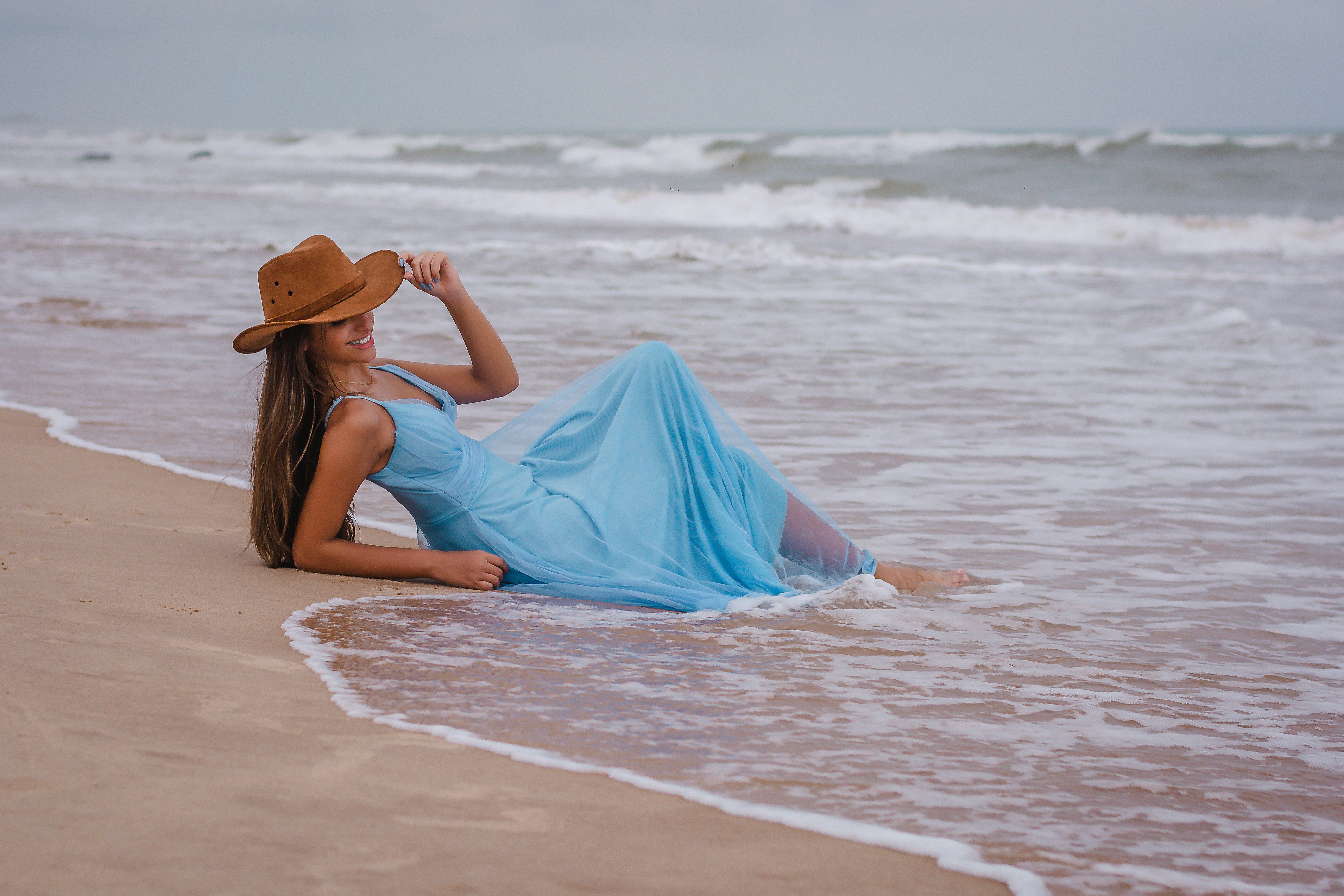 Woman in a Blue Dress and Hat Posing on a Beach Free Stock Photo Woman in a Blue Dress and Hat Posing on a Beach Free Stock Photo