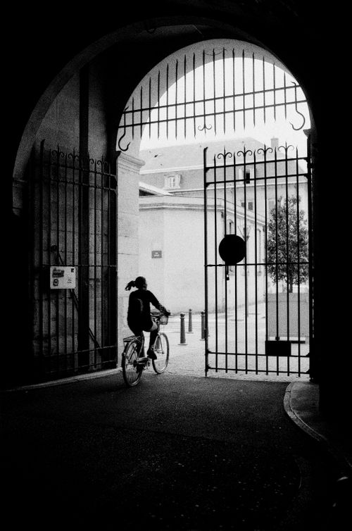 Free A cyclist rides through an arched gate in Nancy, France, showcasing classic city life. Stock Photo