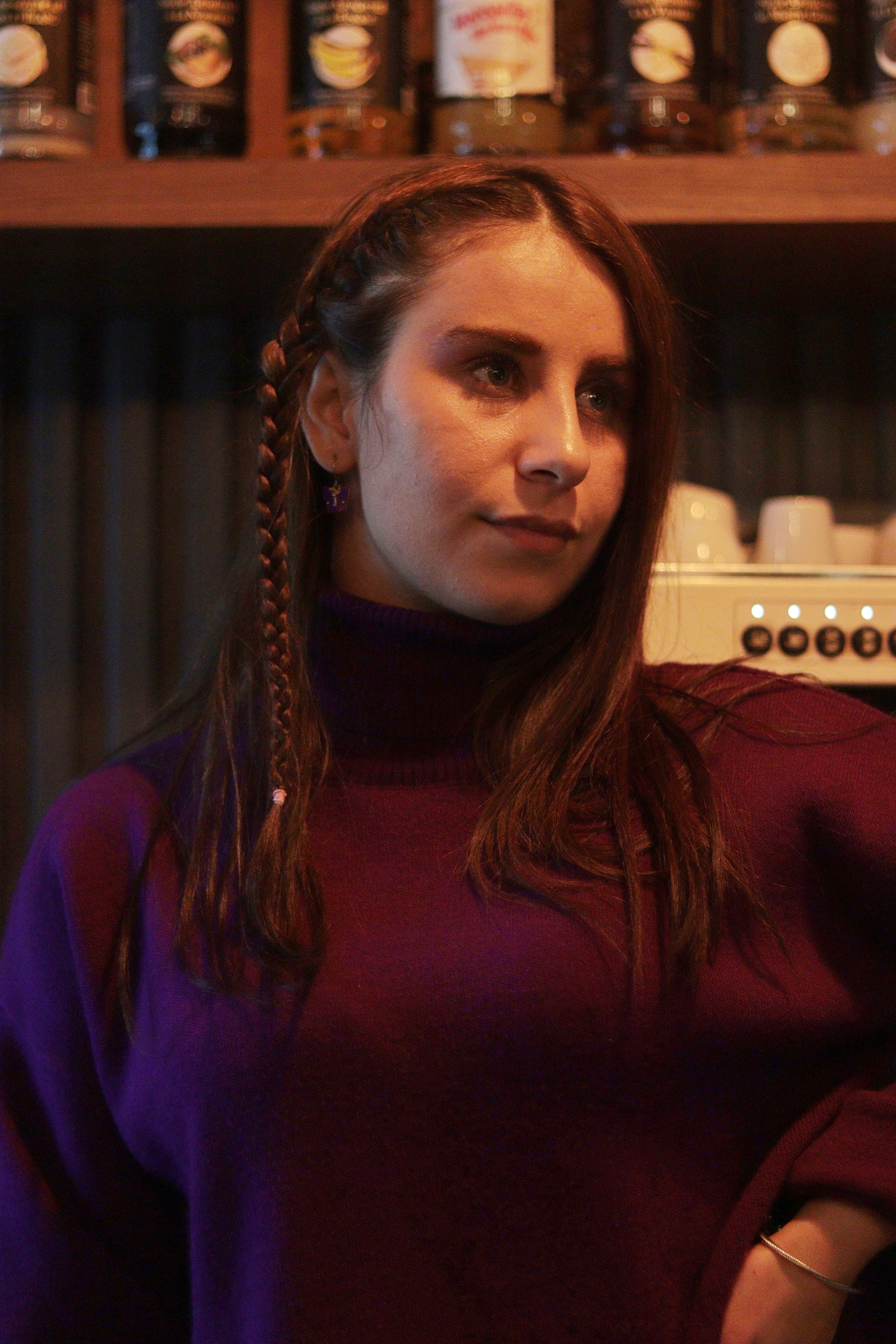Warm portrait of a woman with braided hair in a cozy café.