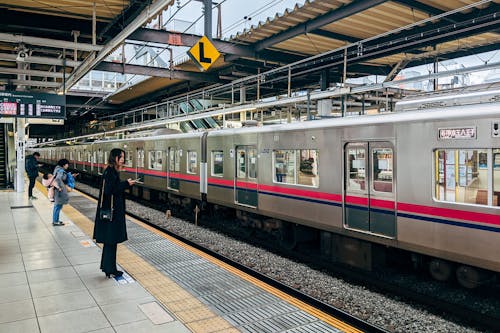 A train is parked at a station with people waiting