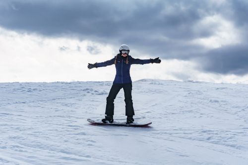 Free Woman enjoying snowboarding on a winter day in Tylicz, Poland. Stock Photo