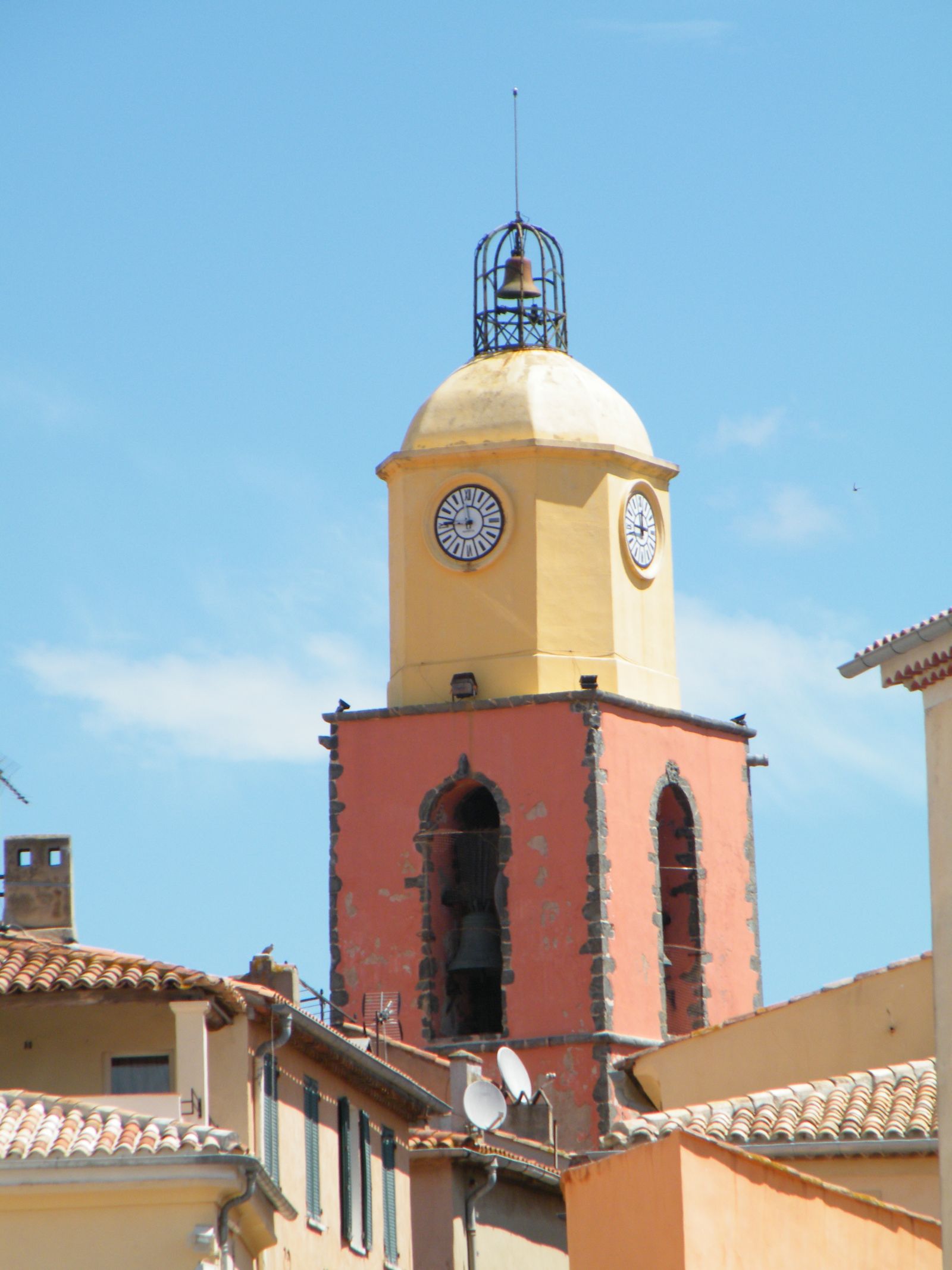 The yellow and terracotta bell tower of Saint-Tropez's parish church above tiled rooftops