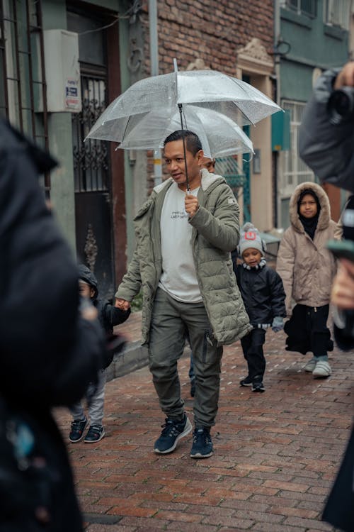 Free A man walking down a street with an umbrella Stock Photo