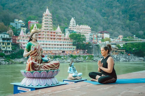Elderly Woman Meditating in Front of a Statue of Parvati on the Ganges