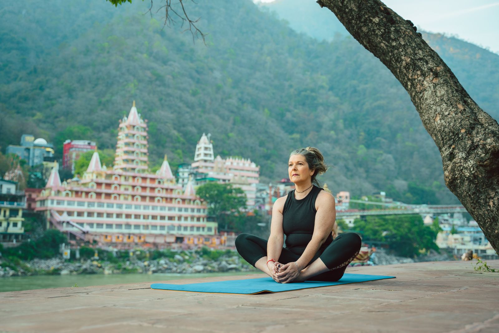 Woman practicing quiet meditation outdoors near a traditional Indian temple setting