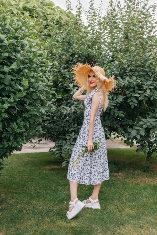 Smiling Woman in a Straw Hat and Summer Dress Standing in the Garden ...