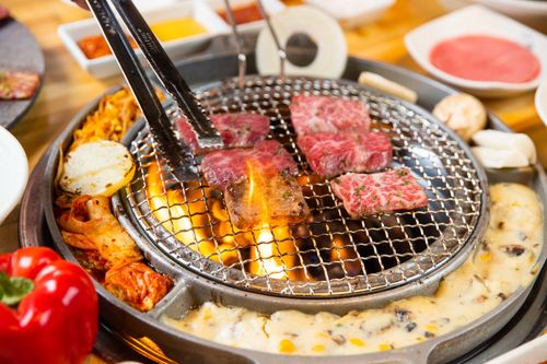 Free A vibrant Korean BBQ grill with sizzling meats and vegetables cooked over an open flame. Stock Photo