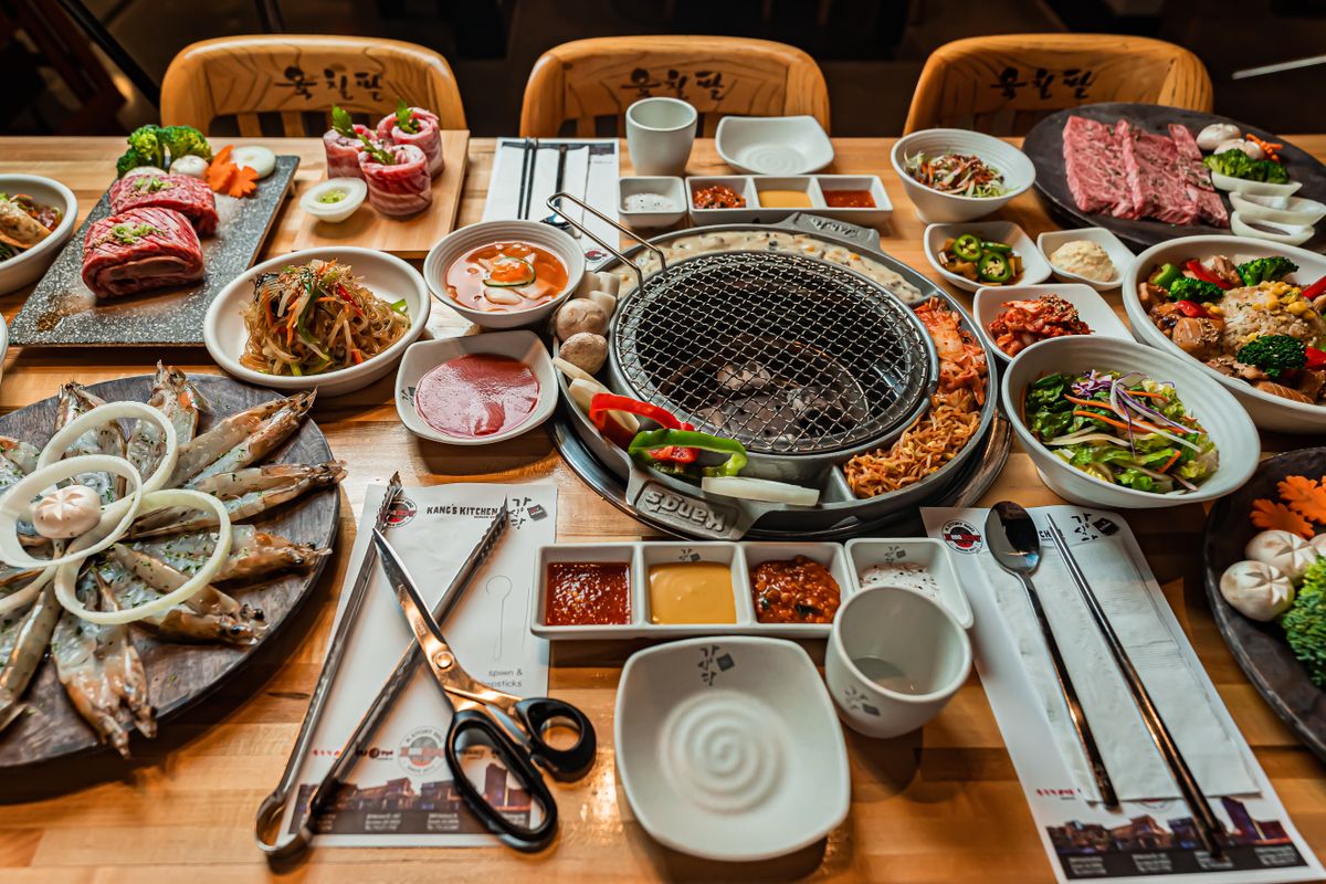 숯불 화로를 가운데 두고 반찬과 고기가 가득 차려진 한식 상차림